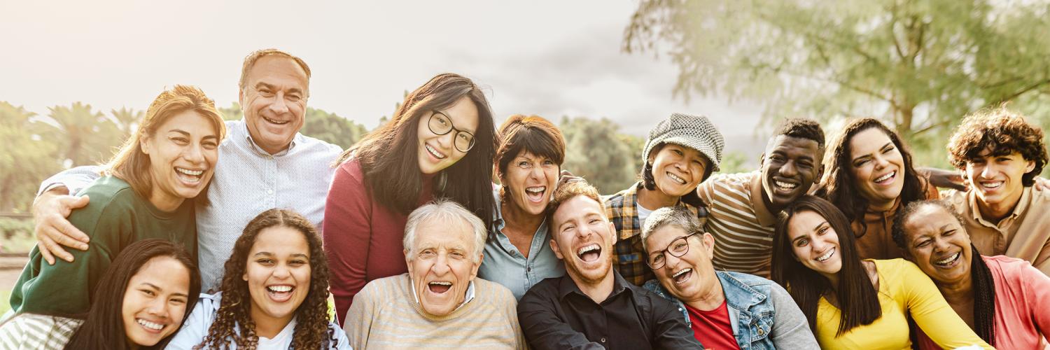 Apple Health is Medicaid A group of smiling people ranging from young adults to elderly. They are seated in two rows with eight in each row.
