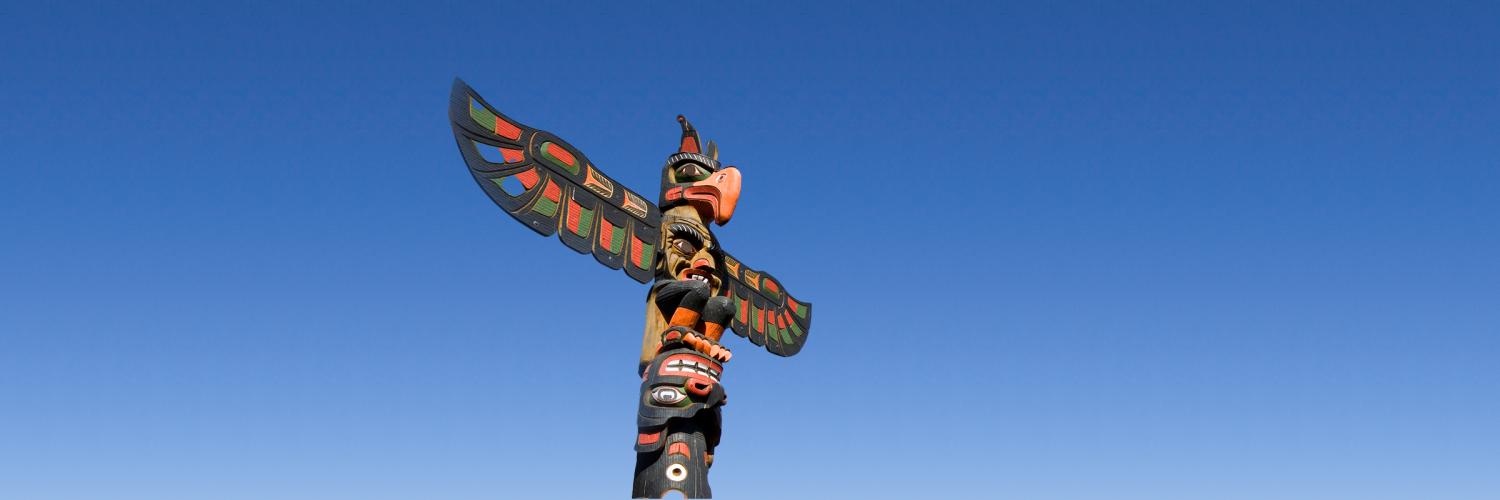 HE Spotlight: WA Tribal Prevention System A beautiful Pacific Northwest tribal totem pole with expanded wings in front of a clear, blue sky.