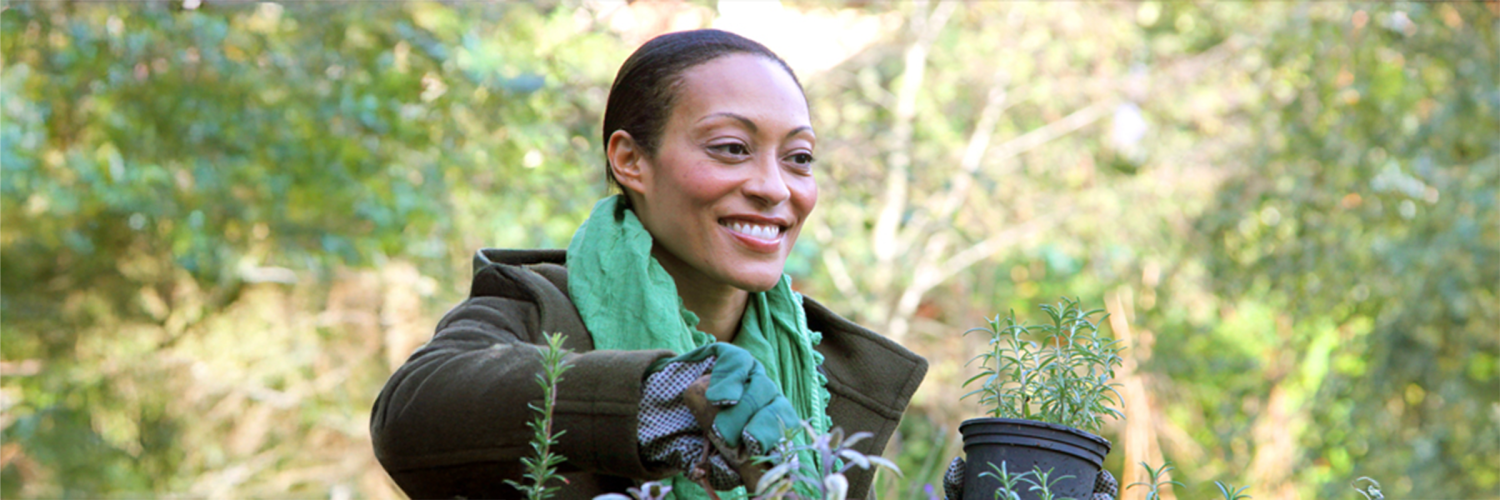 Woman with green scarf working in a garden