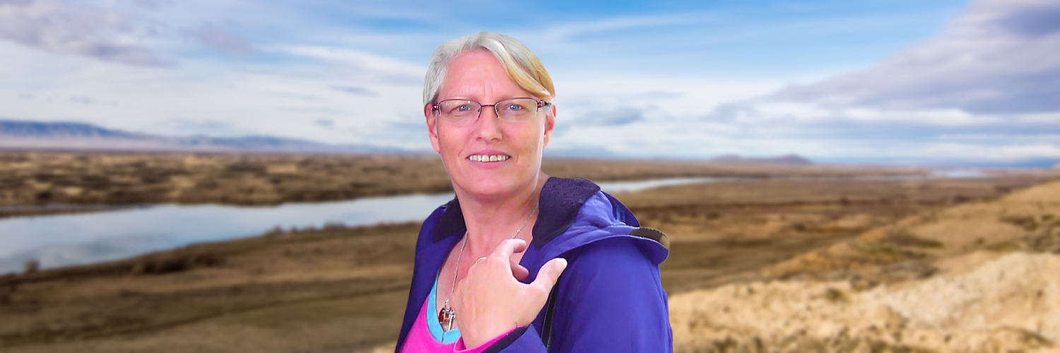 Photo of a female smiling with a background of a river.