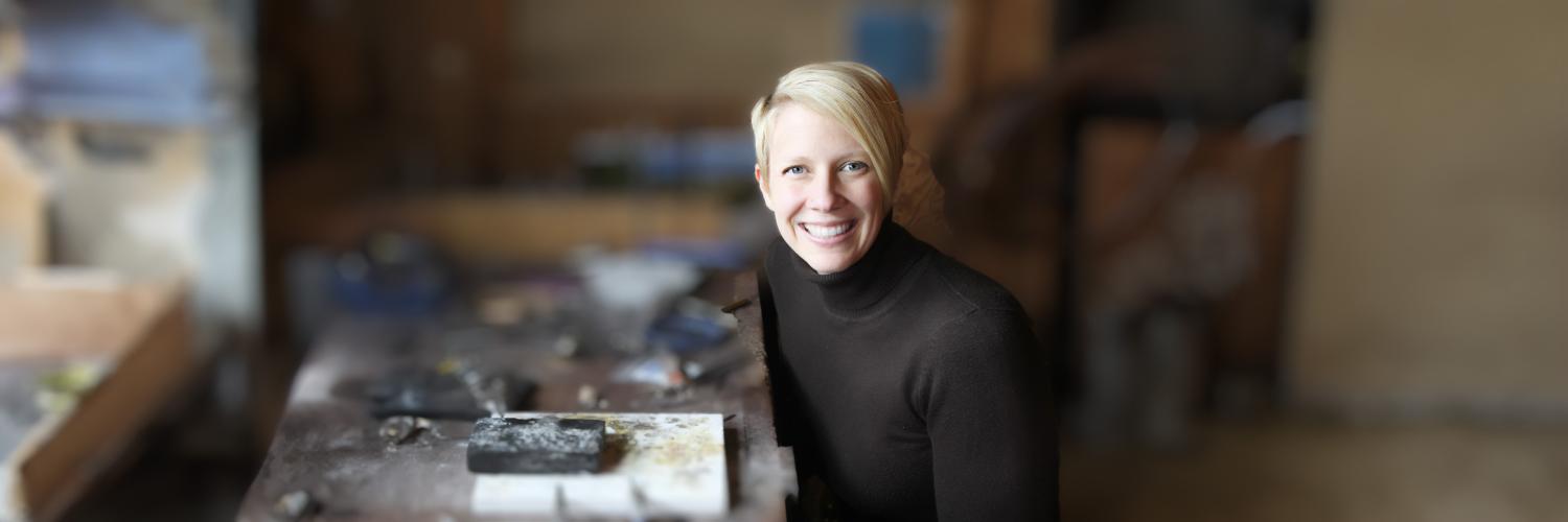 A photograph of a Apple Health client (female) sitting at her craft table with jewelry-making tools.