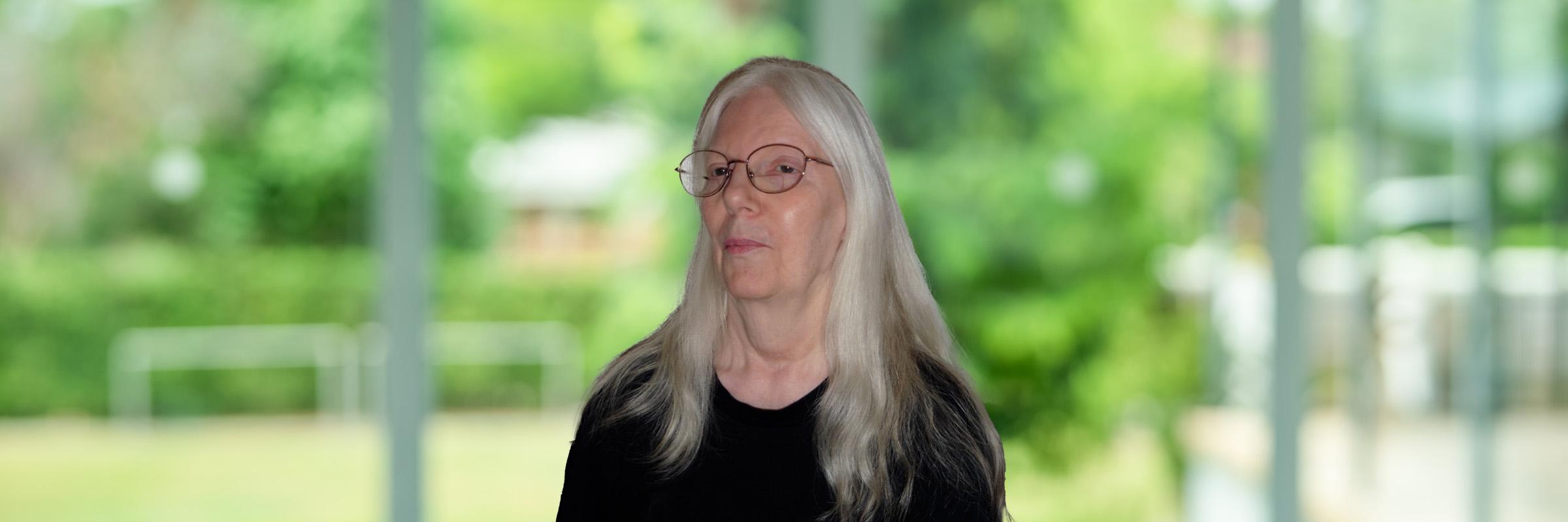 Image of an Apple Health client, Anne, sitting indoors with a nature background behind her. 