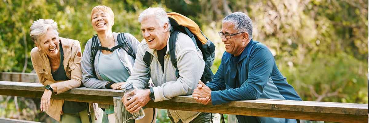 Two men and two women conversing on a bridge