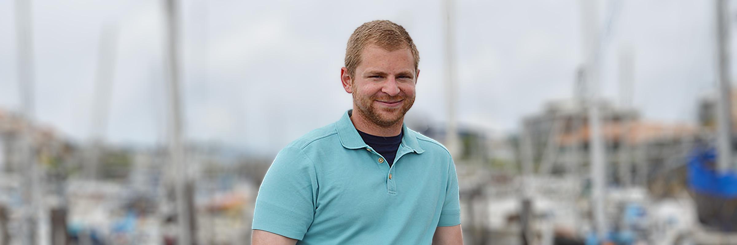 Photo of an Apple Health client standing in a boat pier on a cloudy day. 