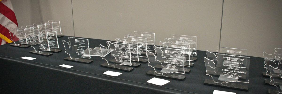 A long table, covered with a black cloth and glass awards shaped like Washington. An American flag is on the left.